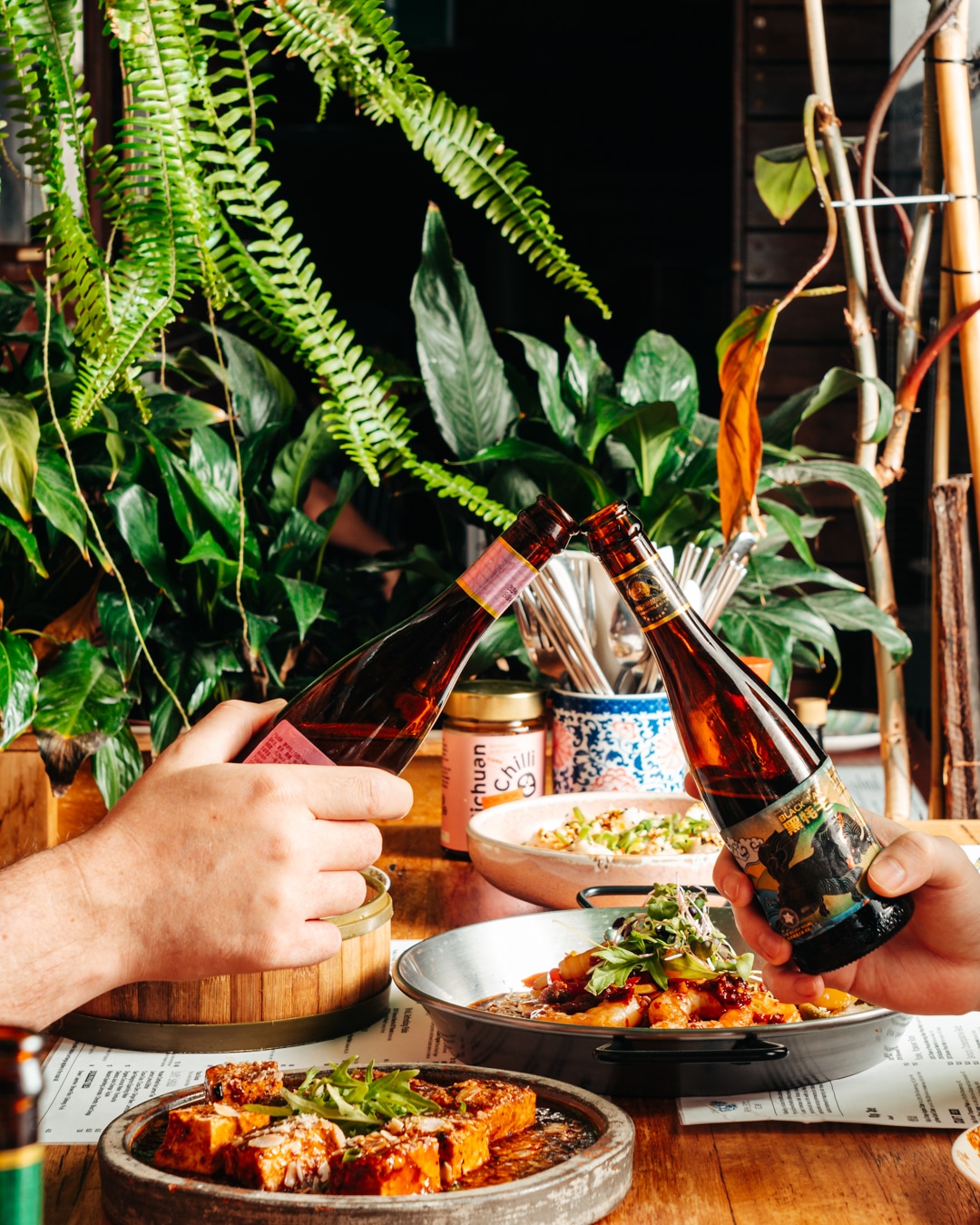 Drink photography of two hands holding beers from a restaurant marketing campaign.