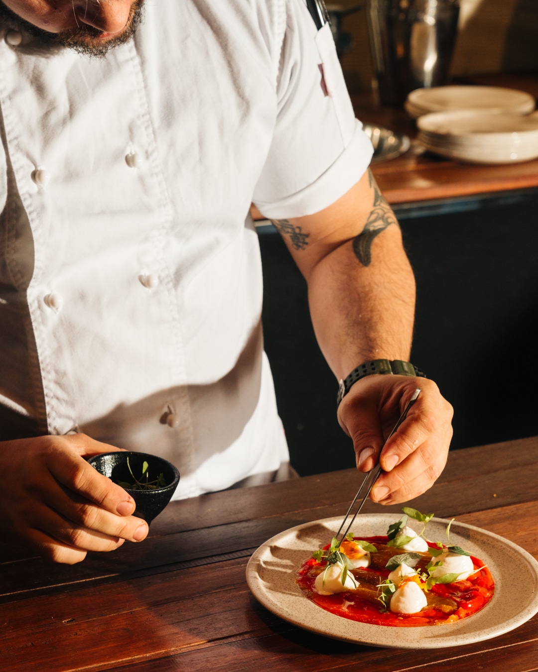 Food photography of chef plating a dish from a restaurant marketing campaign.