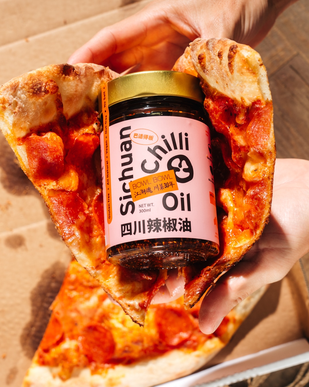 Food photography of jar of chilli oil and pizza from a hospitality marketing campaign.