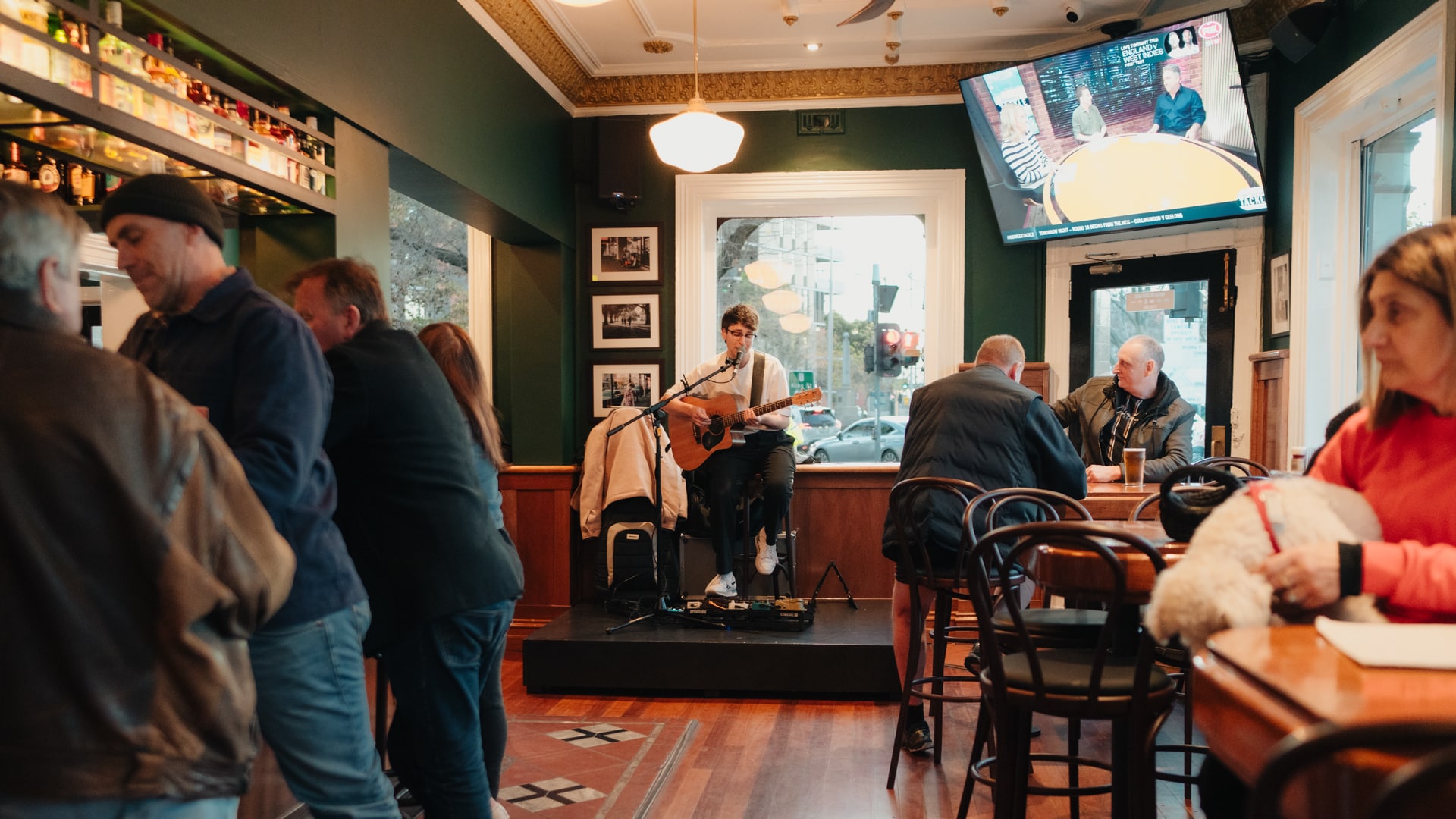 artist playing guitar in busy pub