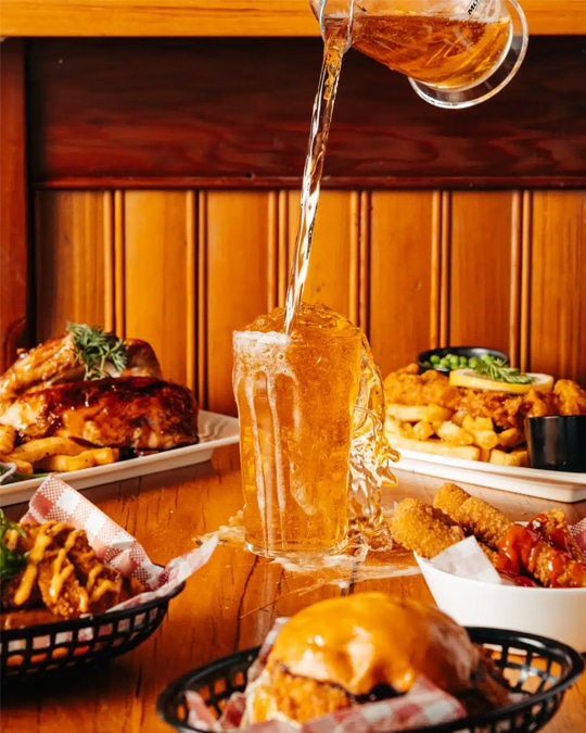 Drink photography of a jug of beer being poured into a glass from a bar marketing campaign.